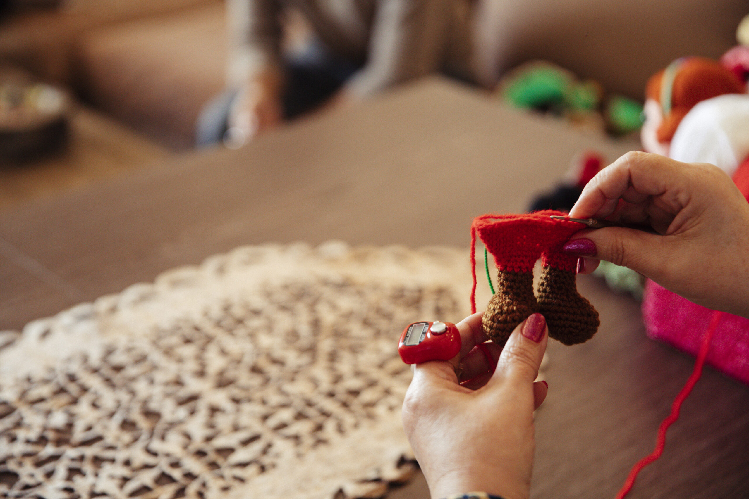 Woman knitting ornaments with red thread